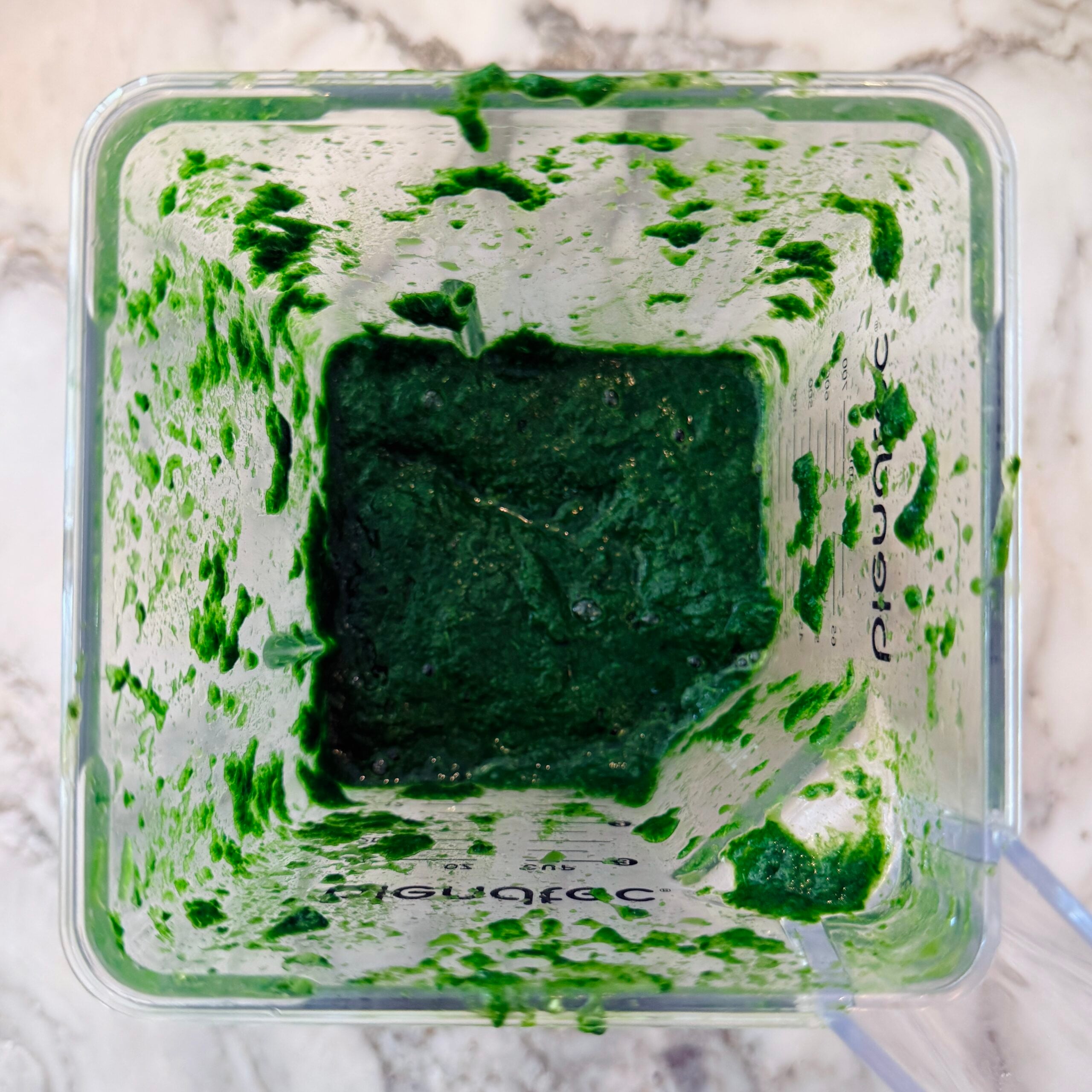 Top view of a blender with pureed spinach. 