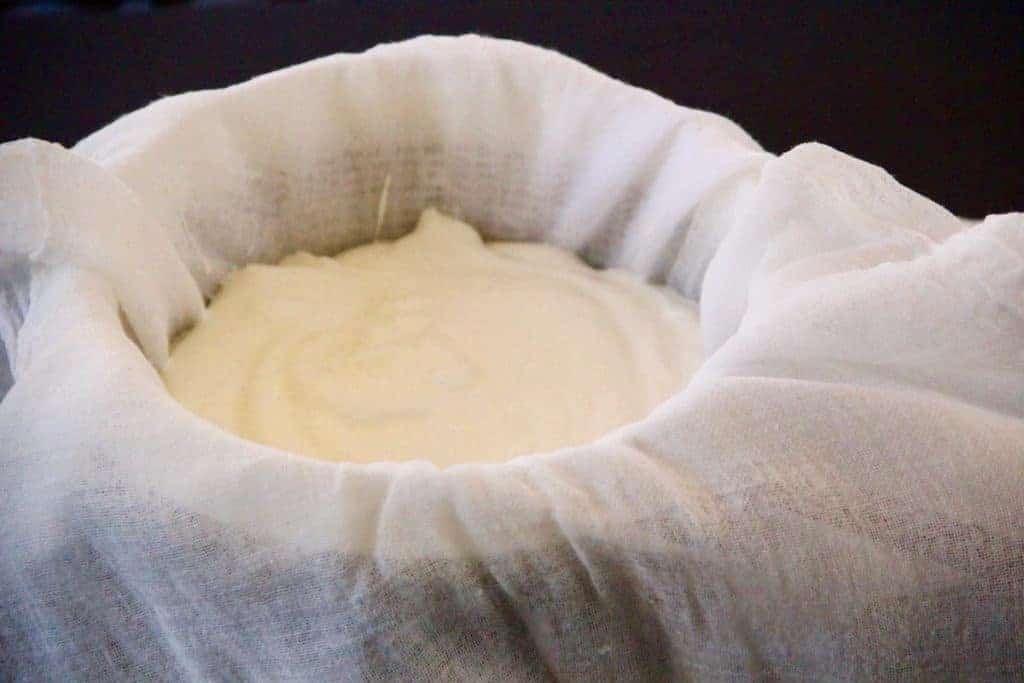 yogurt in a cheesecloth lined bowl 