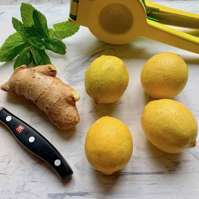 lemons, ginger and mint on a cutting board 