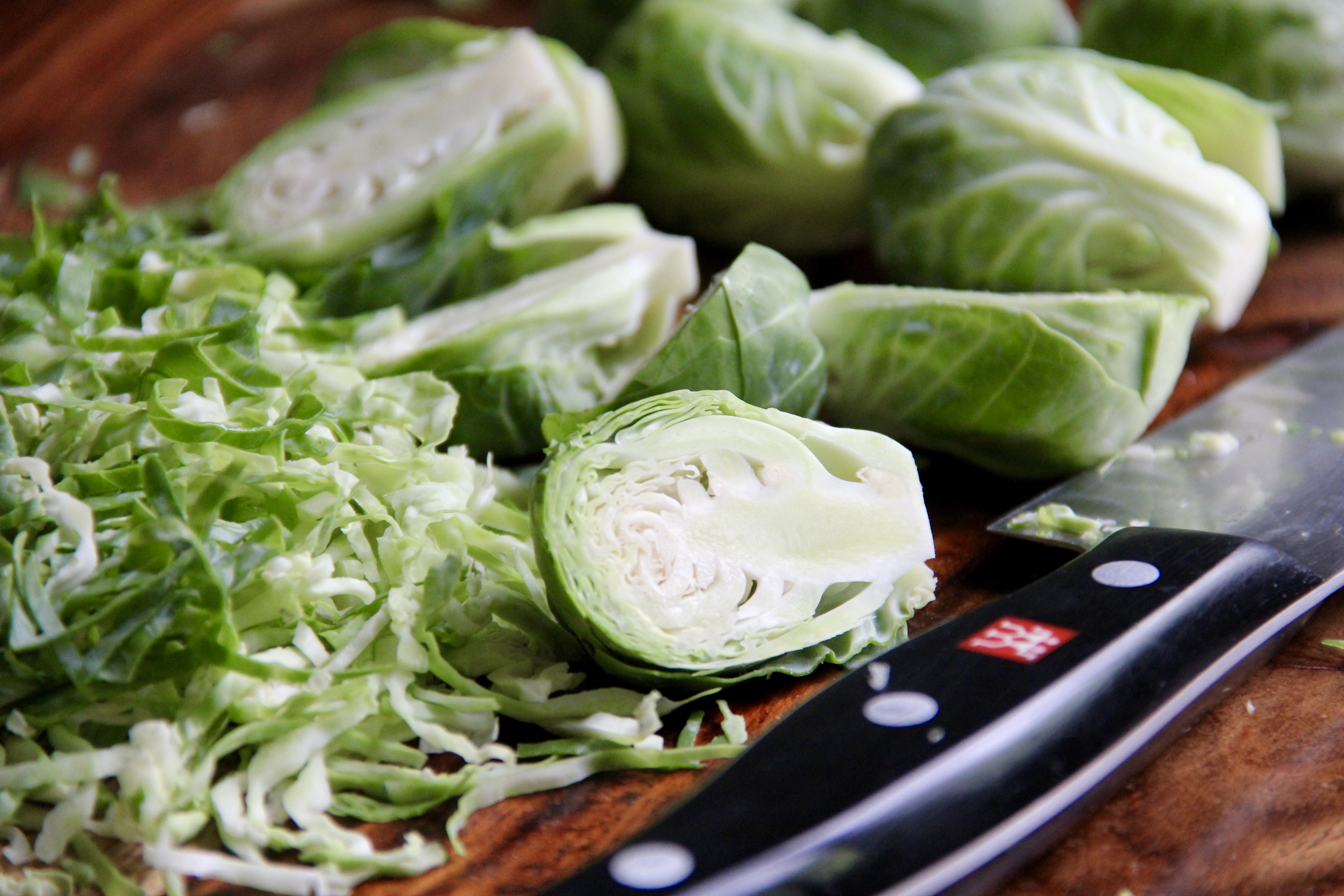 sliced and cut brussels sprouts on a wooden cutting board