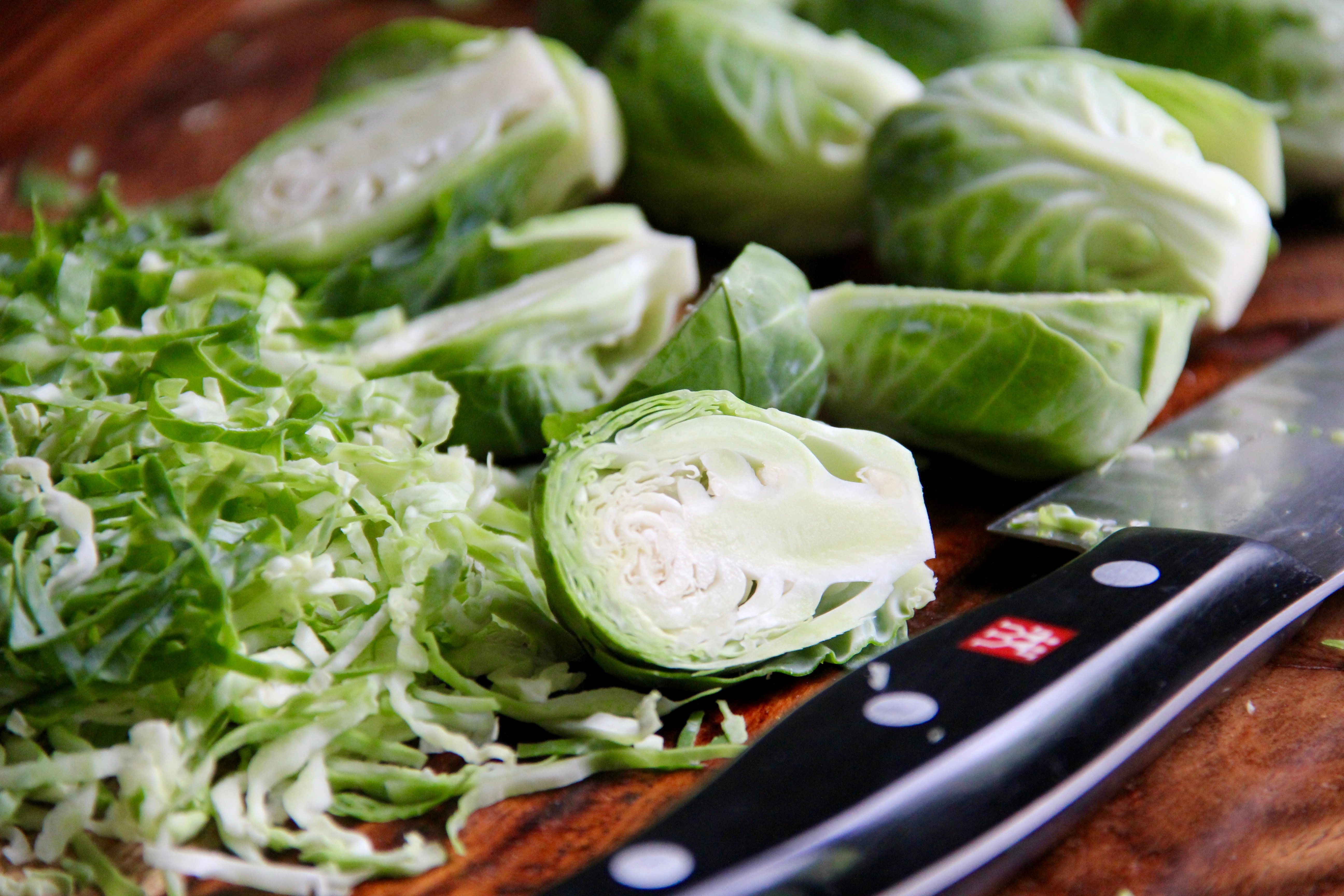 sliced and cut brussels sprouts on a wooden cutting board