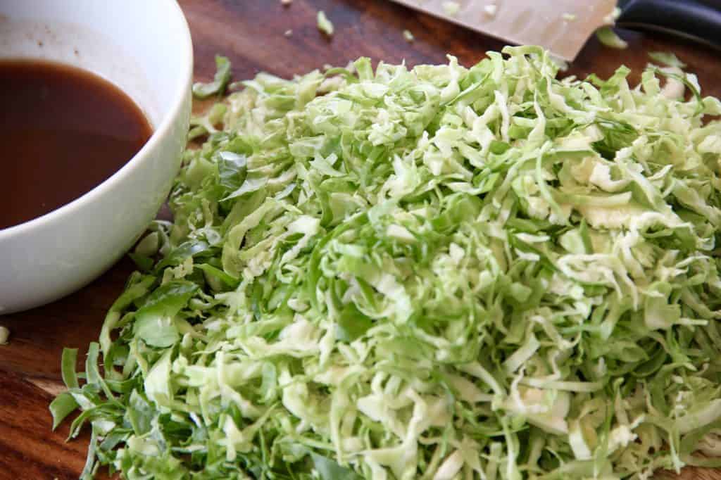 shaved brussels sprouts on a wooden cutting board