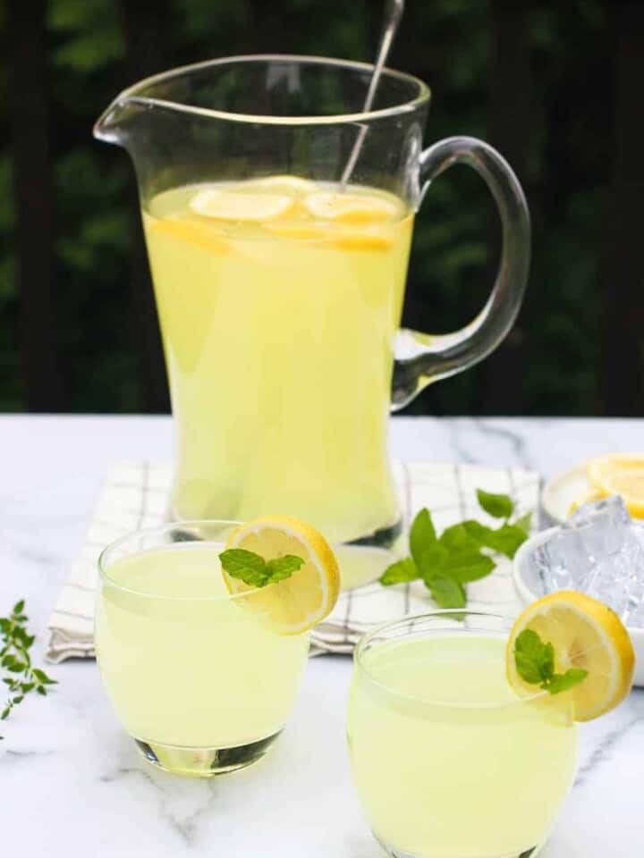 2 glasses and a large pitcher of lemonade