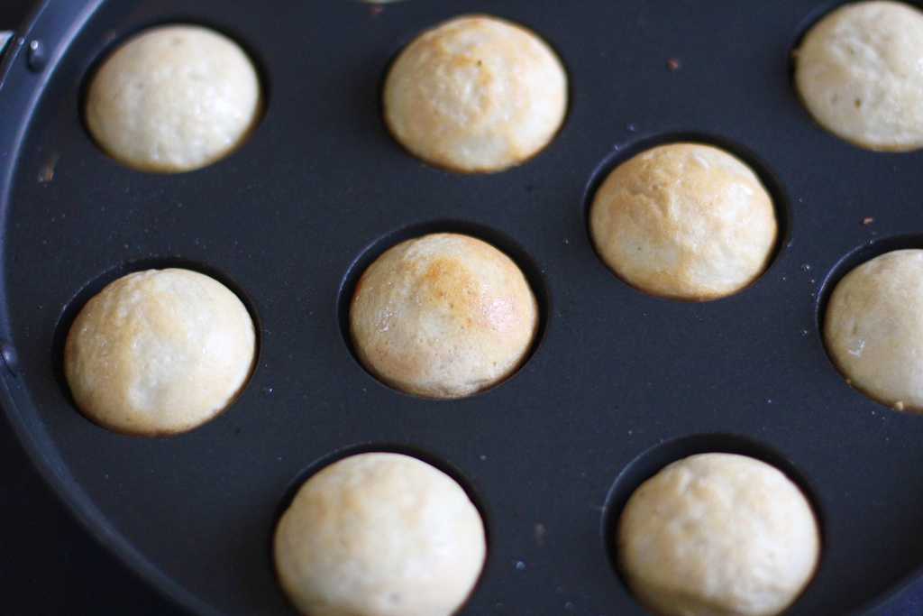 Aebleskiver pan with davivadas cooked on one side 