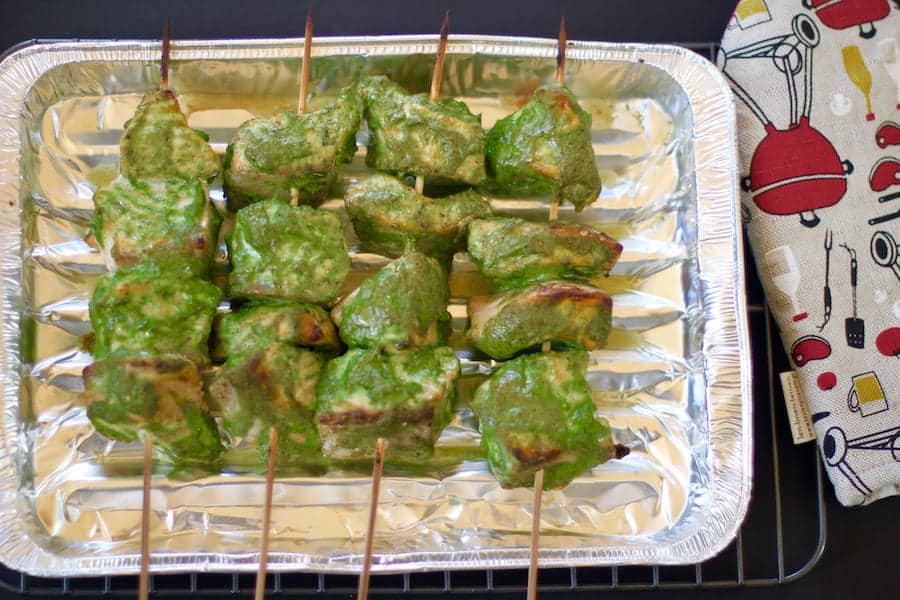 salmon tikka masala skewers on a aluminum tray