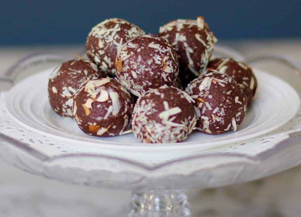 quinoa almonds date energy bites stacked on a cake stand 