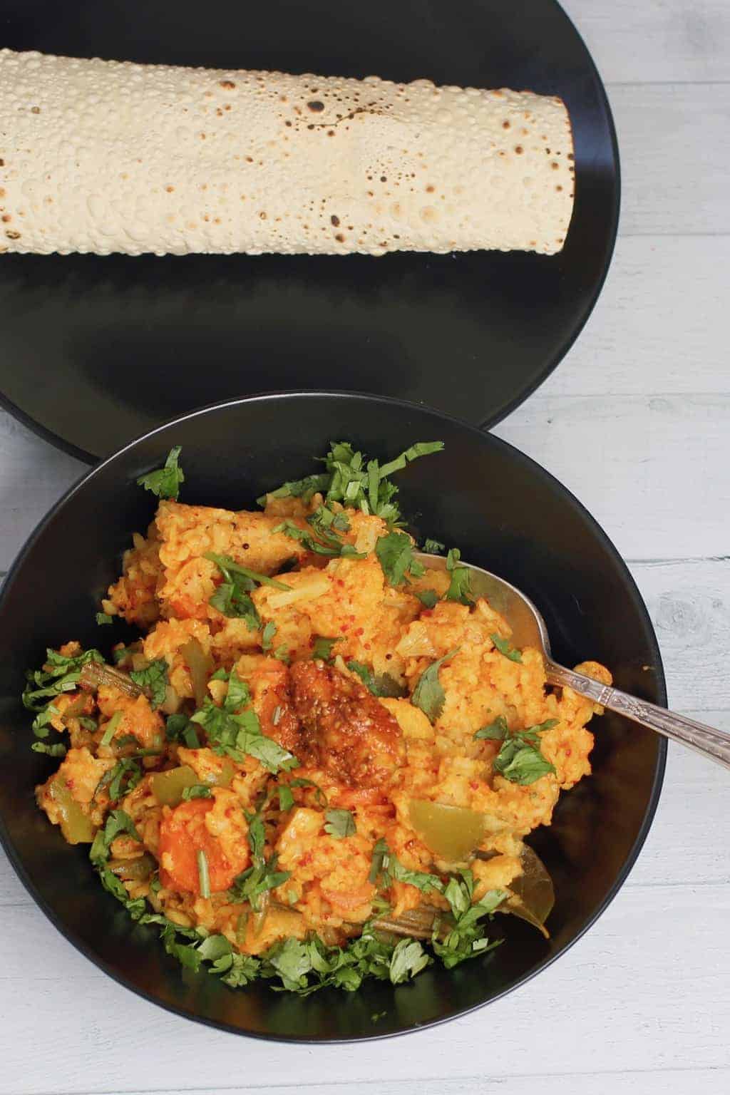 Bisi bele bhath served in a black bowl 