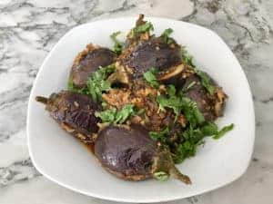 stuffed baby eggplants in a white serving bowl