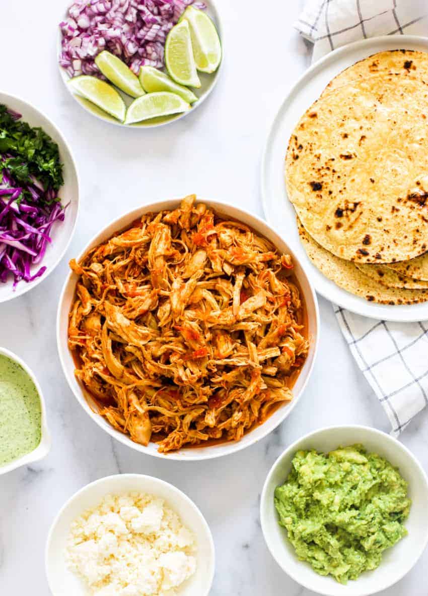 Bowls with Chicken Tinga, corn tortilla and toppings in multiple bowls