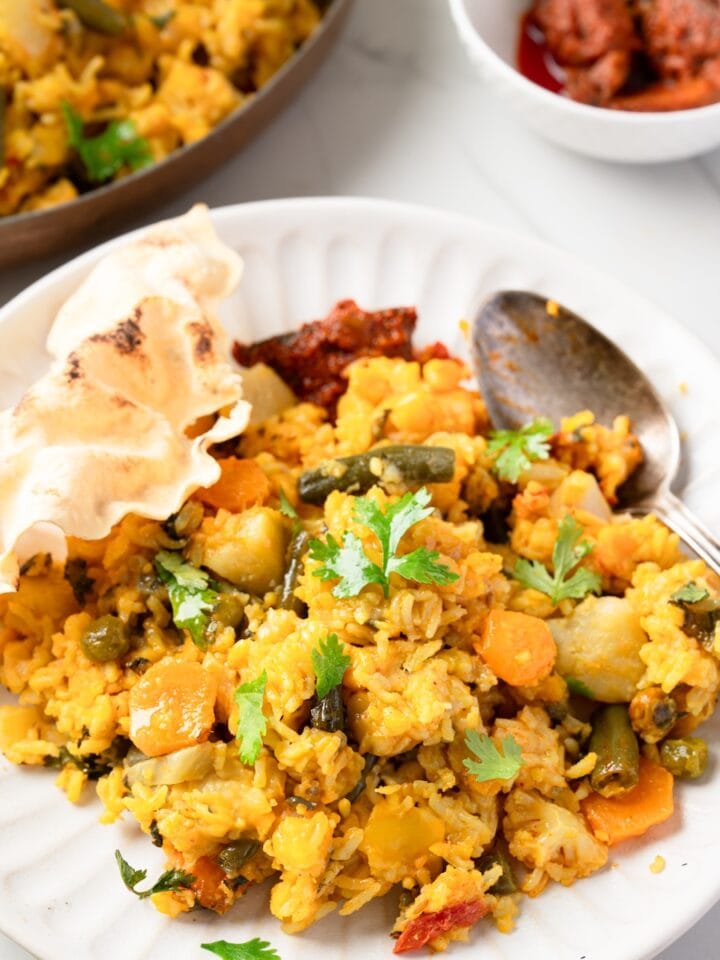 mixed veggie khichdi served with papas and pickle.