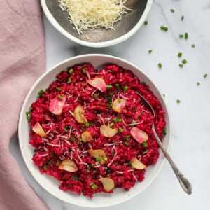 red wine and beet risotto in a white bowl