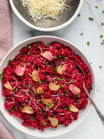 red wine and beet risotto in a white bowl
