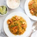 shrimp biryani with raita and lime wedges
