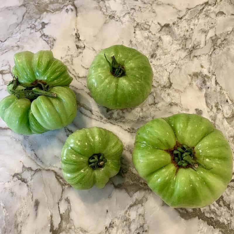 raw green tomatoes on a marble board 