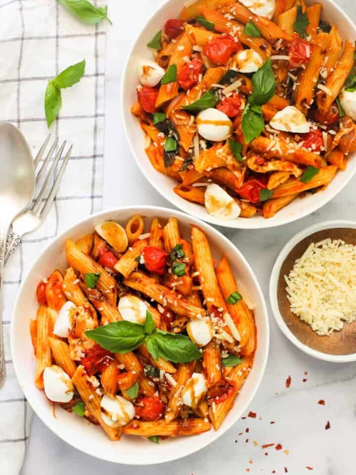 pasta caprese served in 2 white bowls