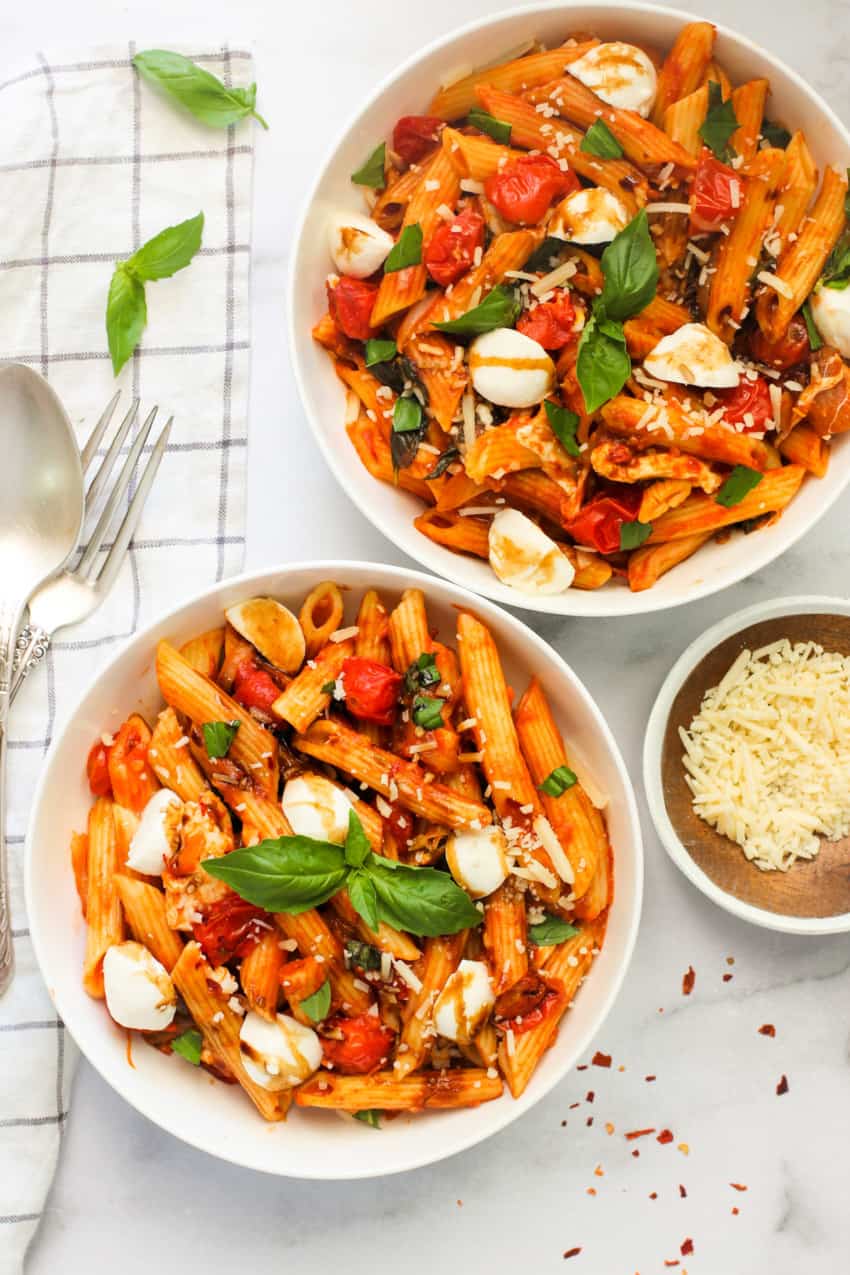 pasta caprese served in 2 white bowls