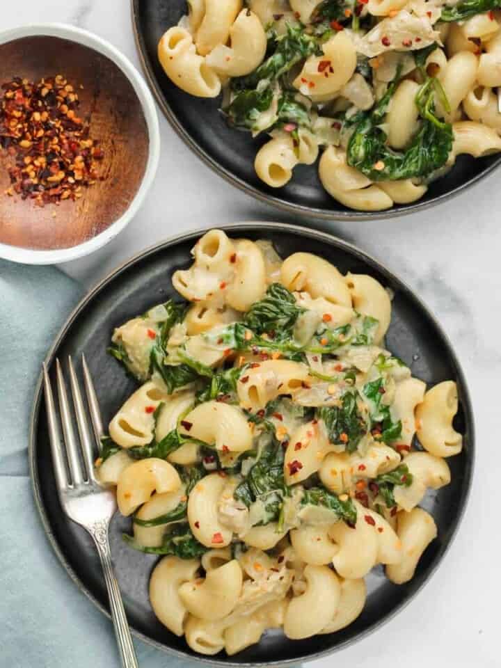 Spinach Artichoke Mac and Cheese pasta served in a black plates