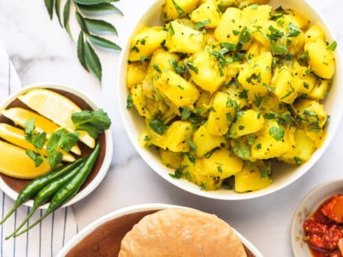 Batata Bhaji served with puri, pickles and lime wedges
