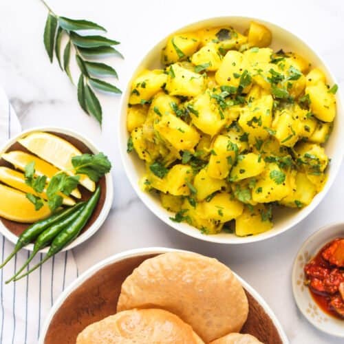Batata Bhaji served with puri, pickles and lime wedges