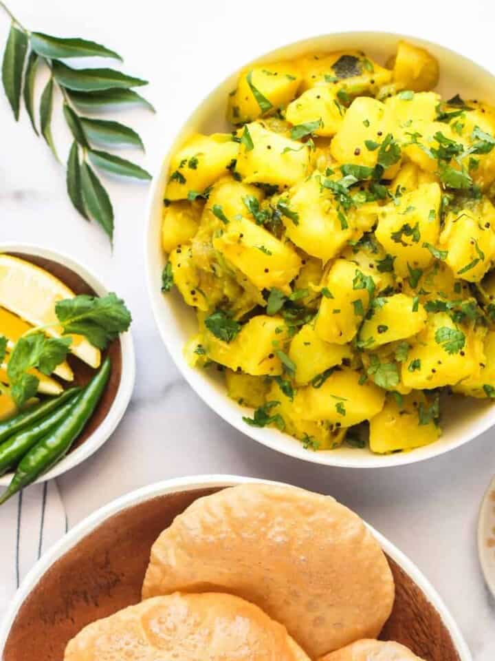 Batata Bhaji served with puri, pickles and lime wedges
