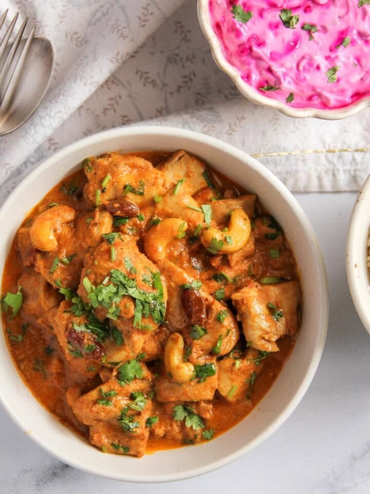 shahi chicken korma served with rice and raita.