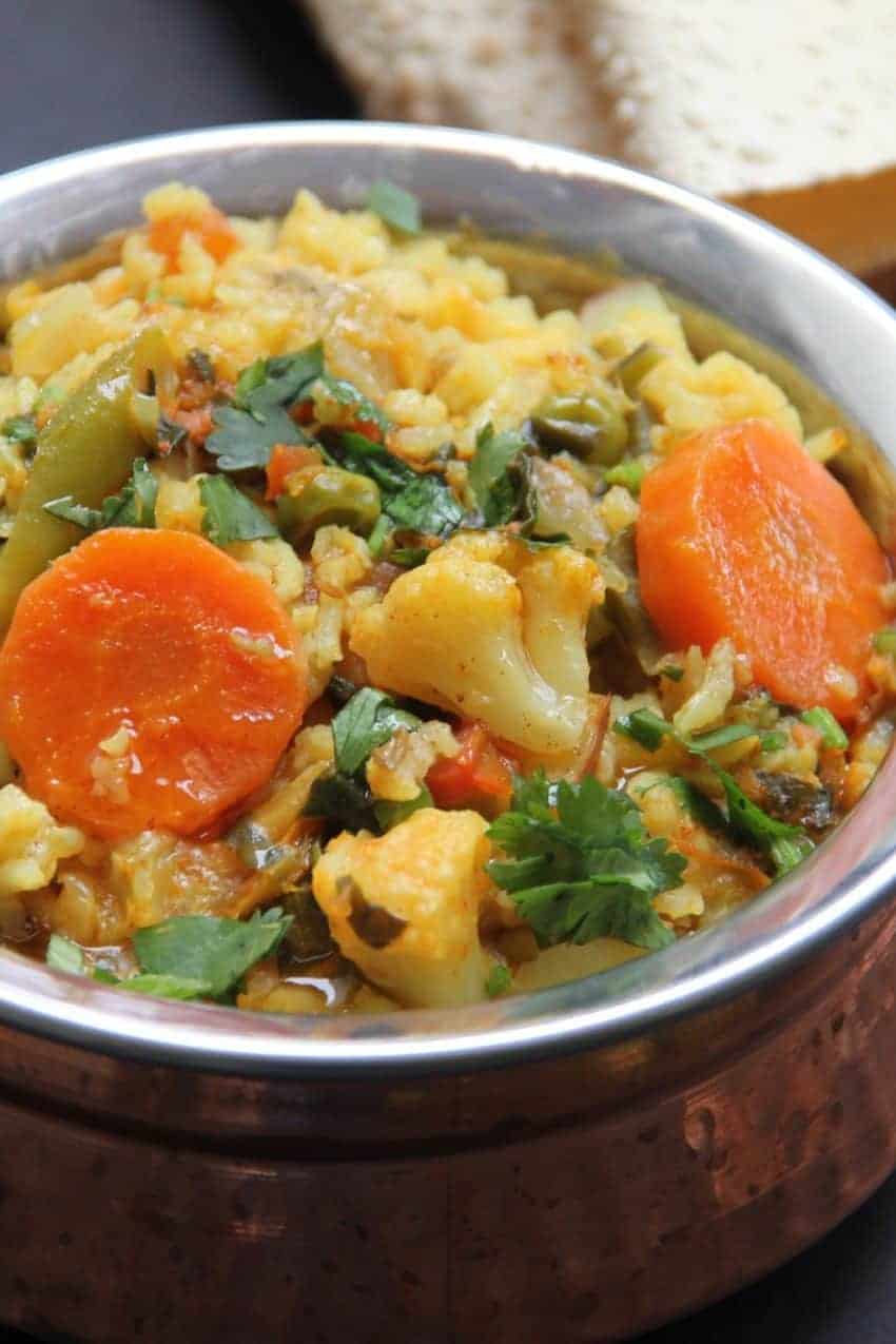 Copper Bowl with vegetable & lentil khichdi , roasted papadums on the side.