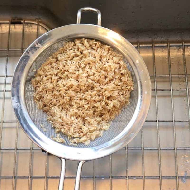brown rice washed in a strainer 