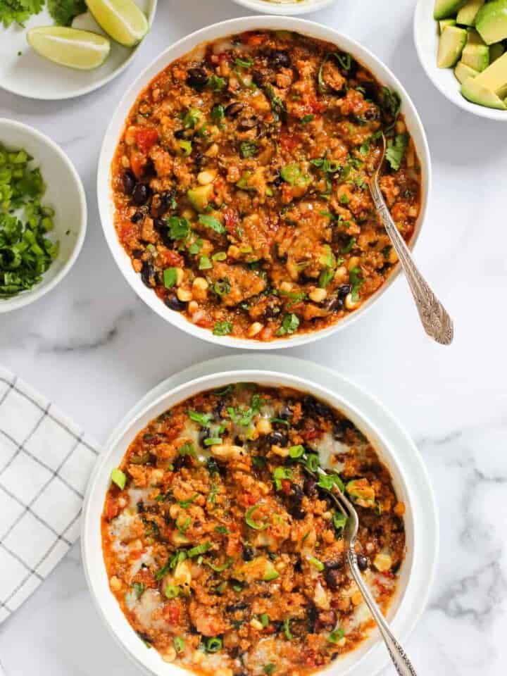 Chicken enchilada quinoa served in 2 white bowls.