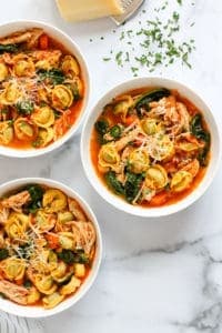 3 white bowls with chicken tortellini soup