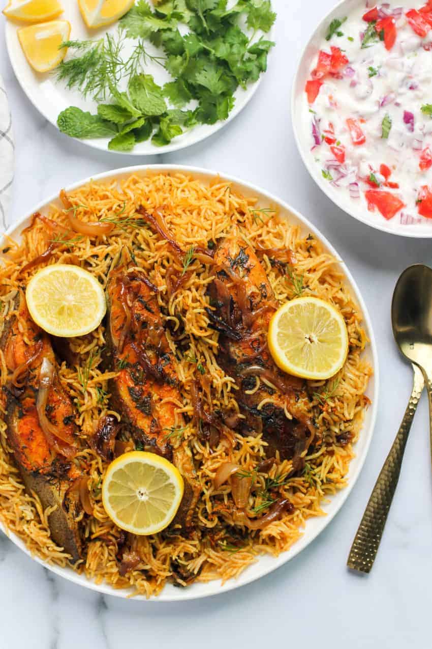 Fish Biryani on a plate with lemon slices on top