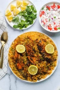 Fish Biryani with Raita, lemon wedges and cilantro
