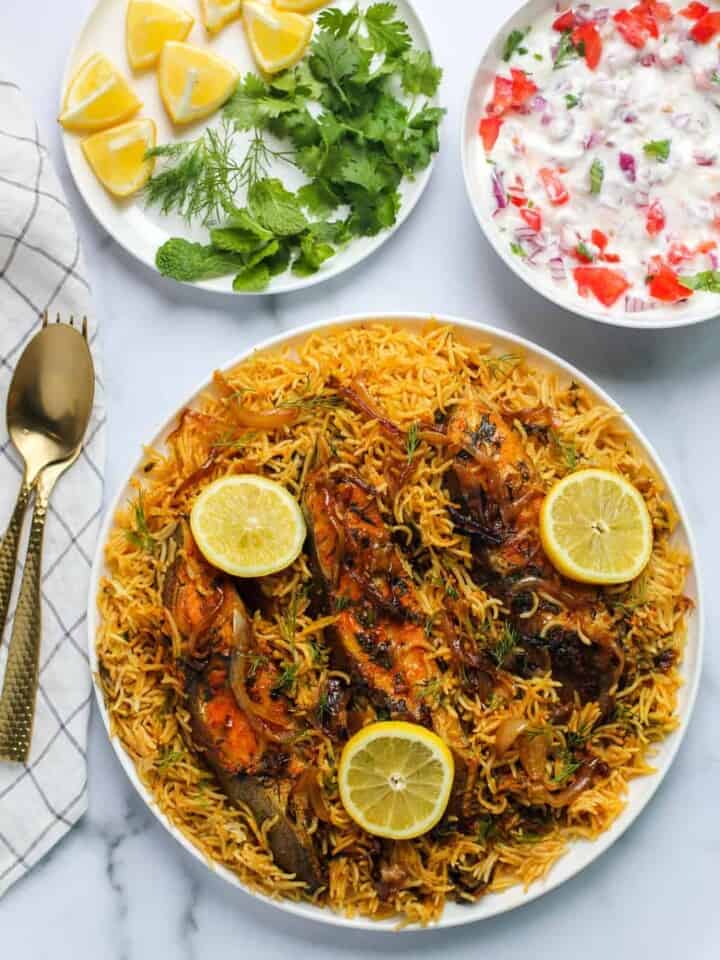 Fish Biryani with Raita, lemon wedges and cilantro