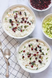 Curd Rice in 2 bowls garnished with cilatro and pomegranate seeds