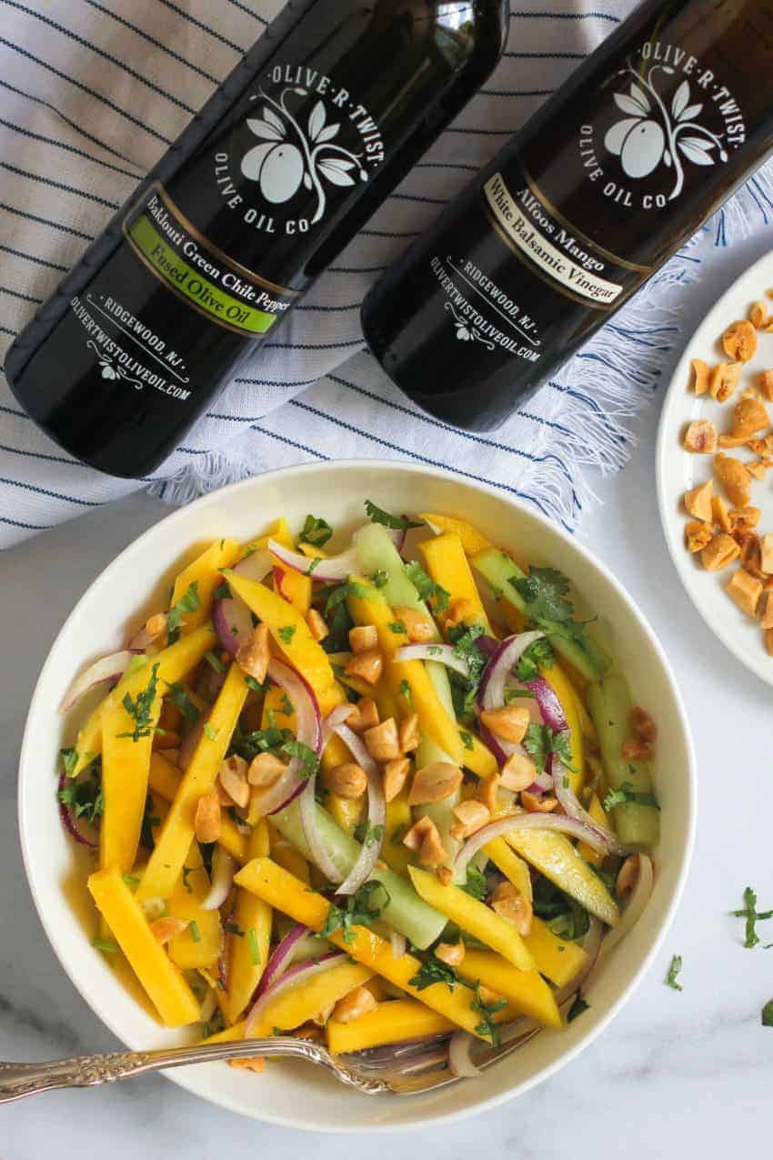 Mango salad with white balsamic vinegar and infused olive oil bottles