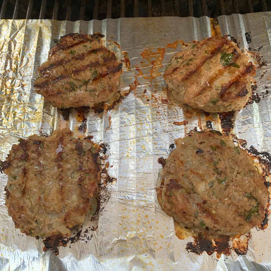 cooked masala chicken burgers on an outdoor grill. 