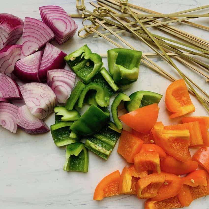 onions and peppers cubed alongside wooden skewers 