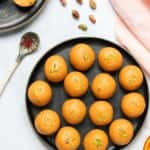 Besan Ladoo in a platter with saffron and pistachios on the side