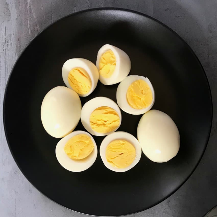 Hard boiled eggs in a black bowl