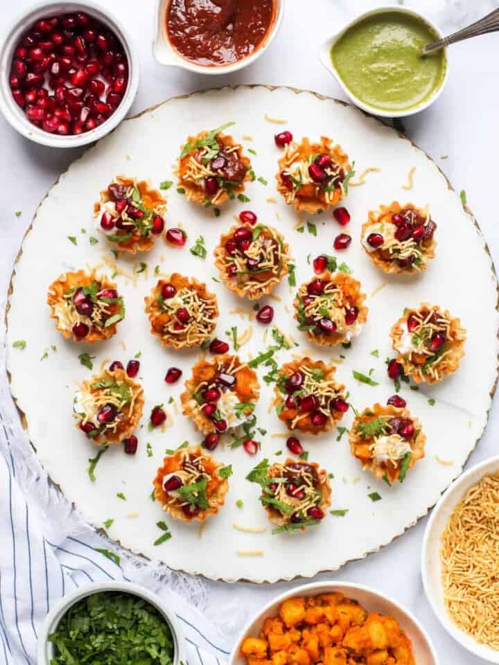 potato chaat served with garnish bowls on the side