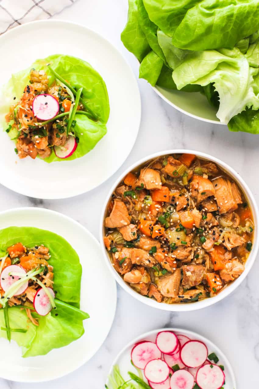 sweet and tangy asian chicken lettuce wraps on 2 plates and asian chicken in white bowl 