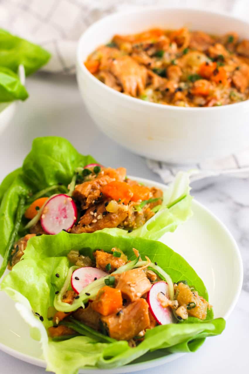 2 sweet and tangy asian chicken lettuce wraps on white plate