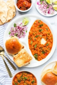 pav bhaji served with diced onions, pickle and papad