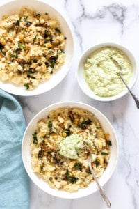 Ven pongal in 2 white bowls with coconut chutney
