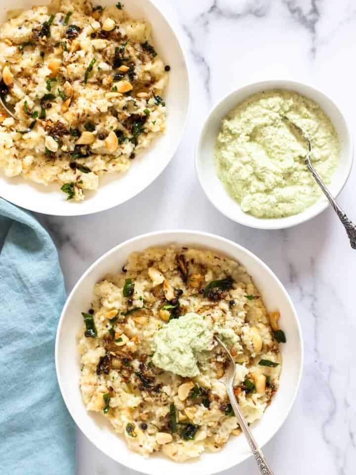 Ven pongal in 2 white bowls with coconut chutney