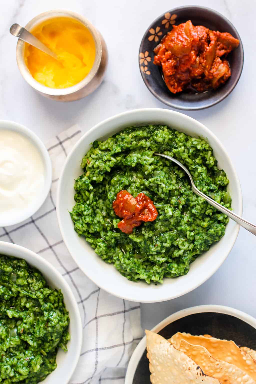 Palak Khichdi served in 2 bowls with pickle and yogurt 