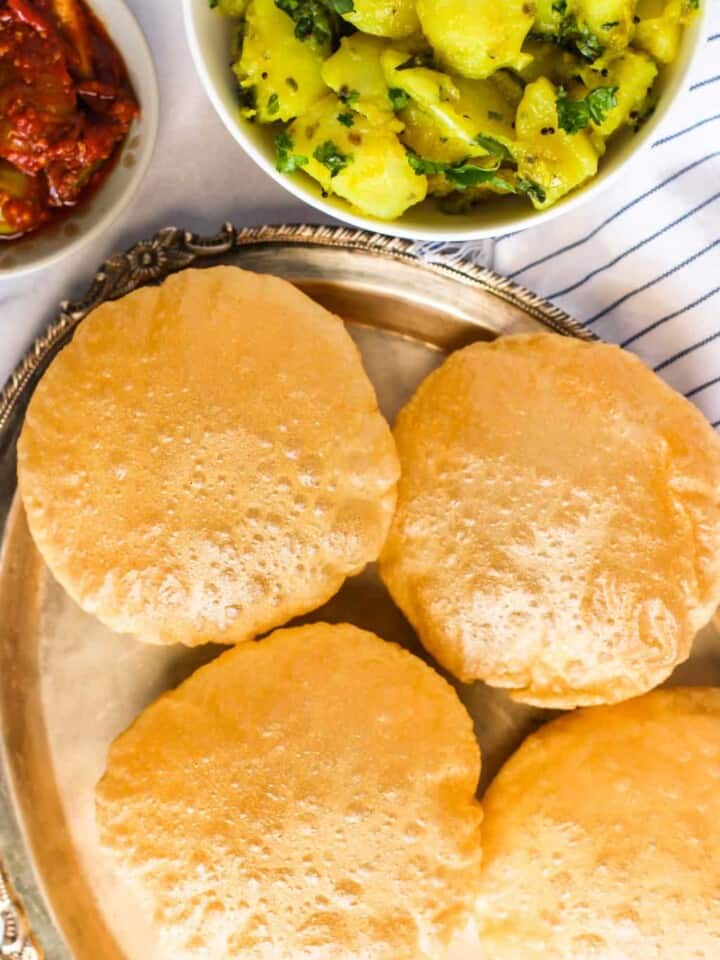 Puri in silver plate with potato bhaji and pickle