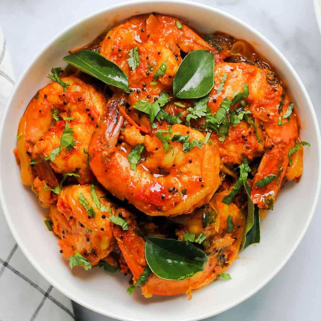 shrimp curry served in a white bowl 