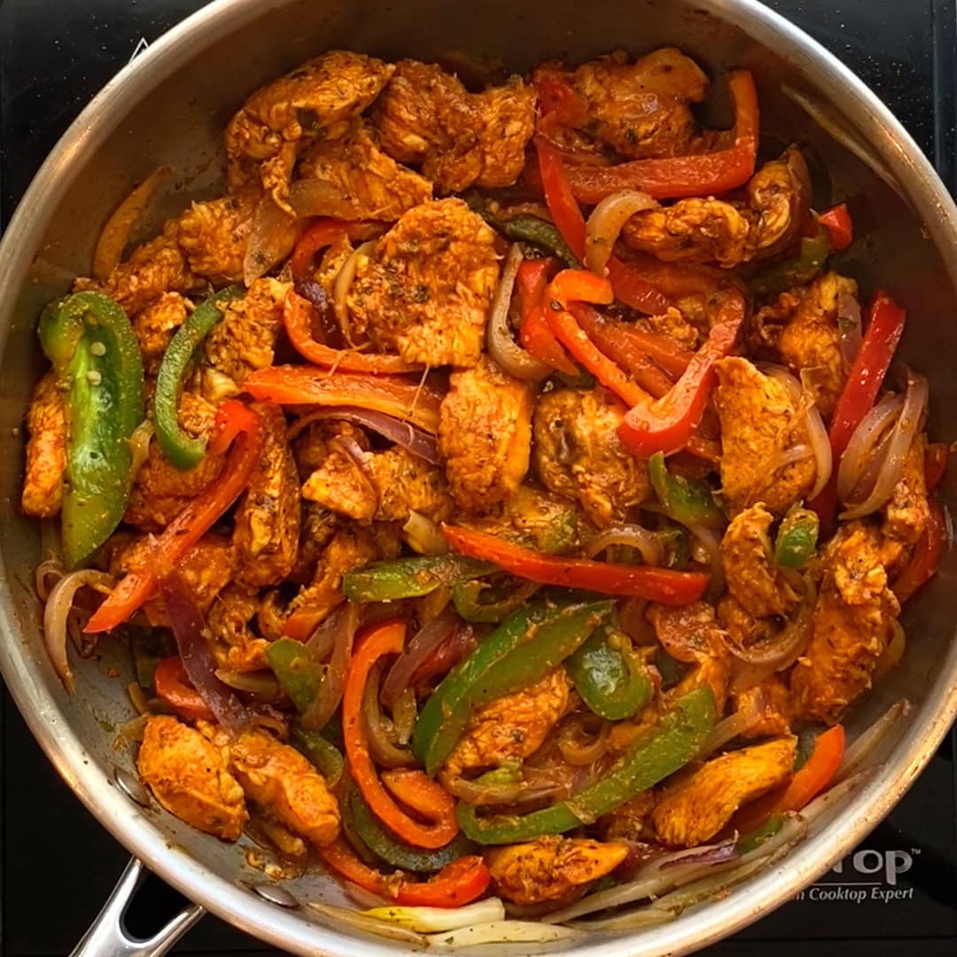 cooked chicken and pepppers in a pan.