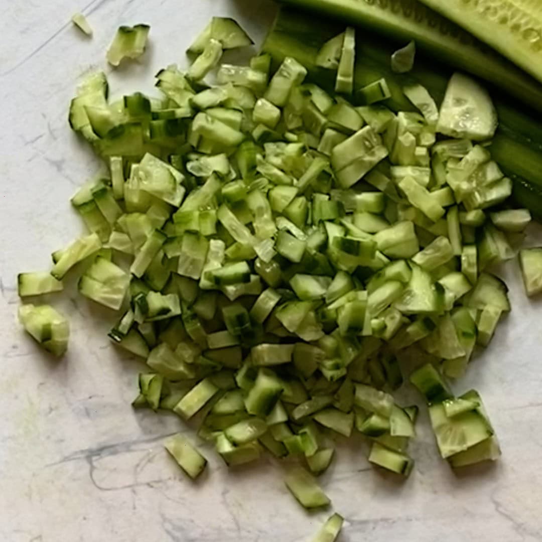 diced cucumbers on a cutting board.
