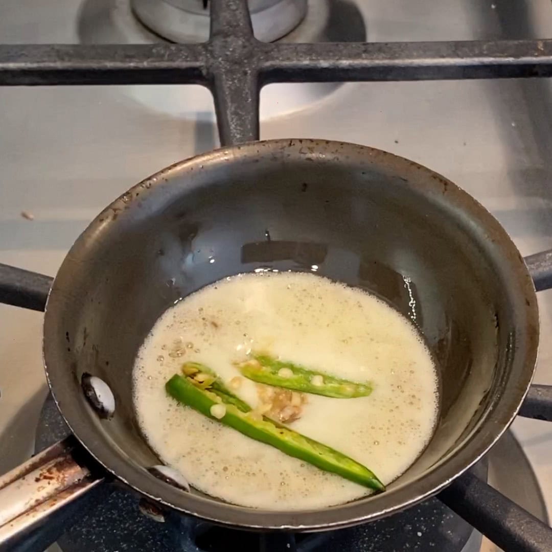 sliced green chilies in hot oil.